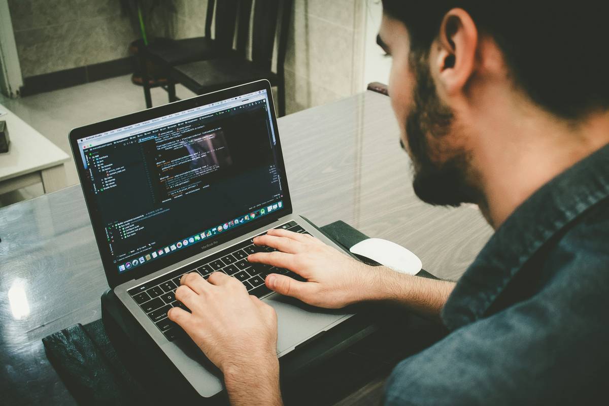 Developer using smart construction developer software to debug a Solidity contract with highlighted vulnerability warnings
